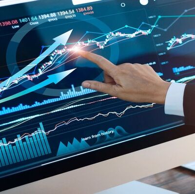 Analyzing data. Hand of businessman touching graph and chart stock market on screen in work place.